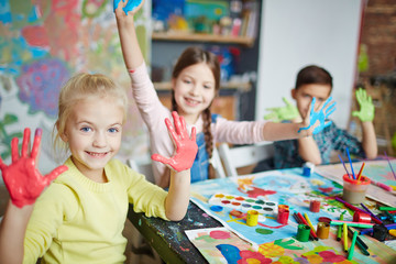 Cute girl and her friends with paint on palms