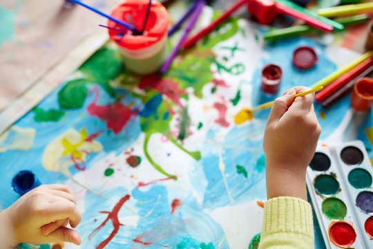 Hand Of Child With Paintbrush Drawing Picture