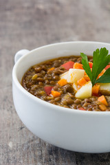 Lentil soup in a bowl on wooden background
