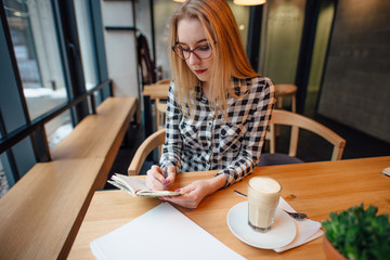 Blonde busuness woman sitting on the chair in cafe place