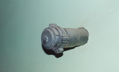 pipe fire hydrant black sticking out of the wall.