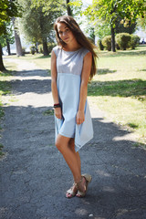 Portrait of beautiful teenage girl in blue blouse, against green