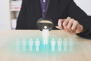 businesswomen hand holding magnifier choose people icon. concept employment recruitment hiring.
