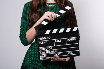 Closeup of a movie clapper keeps the girl in the green dress