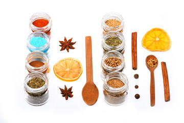 various spices in spoons, jars, dried lemon on white background