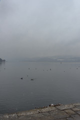 Foggy winter scenery at the lake of Kastoria Greece, during a he - 136319039