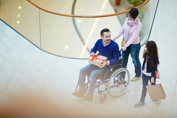 Disabled man, his wife and daughter shopping together