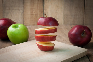kitchen table with stack of slice red apple  on cutting board - healthy eating and healthy food concept.