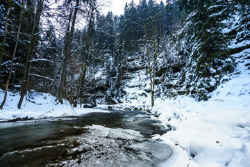 snow and ice by the river in mountains