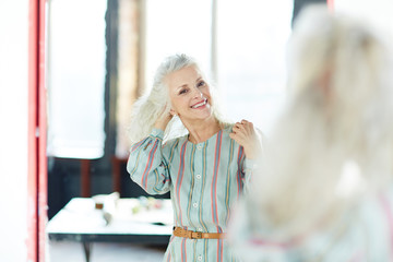Retired woman looking at herself in mirror