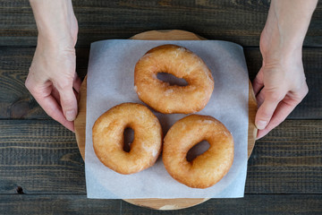 a woman holding a tray of donuts