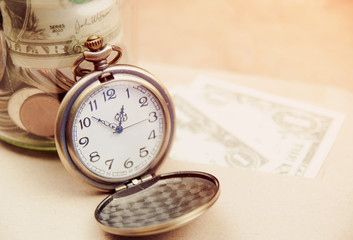 Money saving concept with vintage clock for the past.
