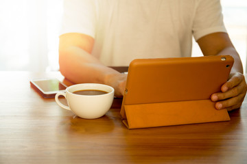 Man using notepad with coffee and cell phone on the table
