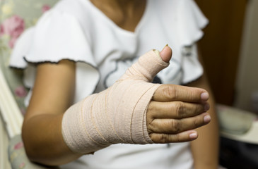 Woman sitting on a chair with Splint broken bone on her hand