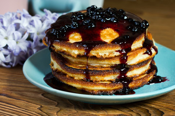 Homemade fluffy pancakes drizzled blueberry jam