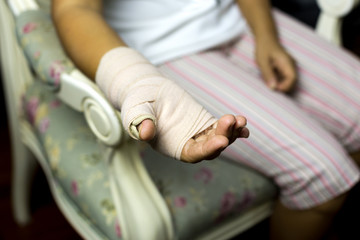 Woman sitting on a chair with Splint broken bone on her hand