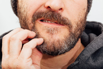 Mann kratzt sich seinen juckenden Bart, untere Gesichtshälfte