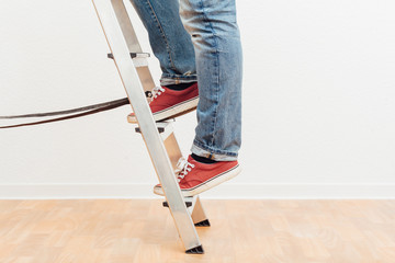 Mann klettert Leiter hoch, untere K&ouml;rperh&auml;lfte