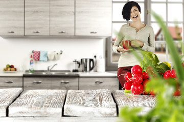 woman in kitchen and vegetables on wooden table 