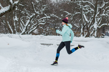 Fototapeta na wymiar Young woman jogging in the winter park
