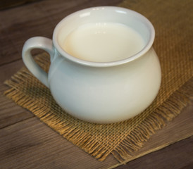 Milk in a bowl on wooden background