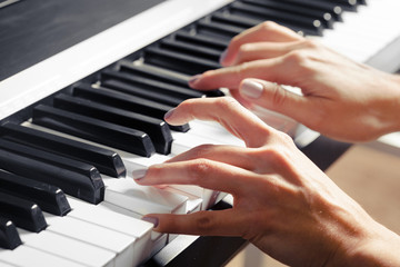 Fototapeta premium Closeup of hands playing piano. Music and hobby concept