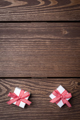 White gift boxes with red ribbon on wooden table. Top view