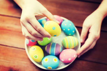 Fototapeta na wymiar close up of woman hands with colored easter eggs