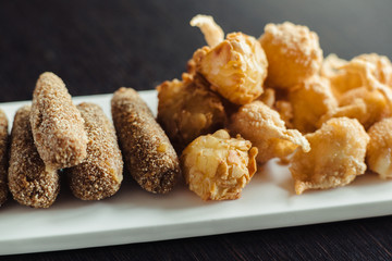 Cheese balls for beer on a white plate on a wooden table