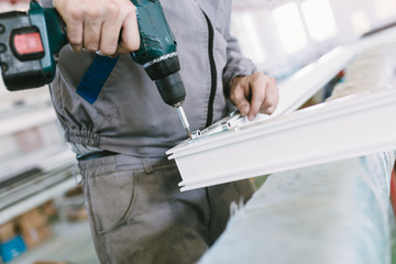 Manual worker assembling PVC doors and windows. Manufacturing jobs. Selective focus. Factory for aluminum and PVC windows and doors production.