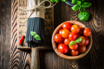 Black spaghetti with tomatoes, basil and hot chili peppers