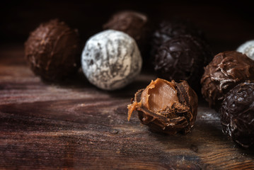 Chocolate,  round truffle pralines filled with nougat on dark rustic wood
