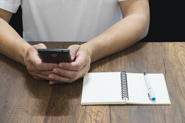 smart phone in man hand with notebook and pen to connecting digi