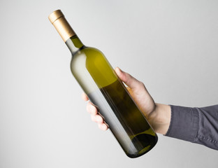 Hand is holding wine bottle