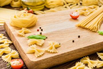 Composition of dry pasta, black pepper, basil and tomatoes