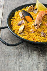 Traditional spanish seafood paella on wooden background
