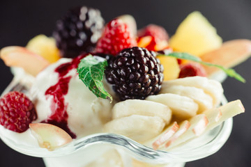 Ice cream with fruit in ramekin.