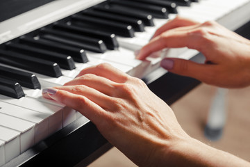 Obraz premium Closeup of hands playing piano. Music and hobby concept