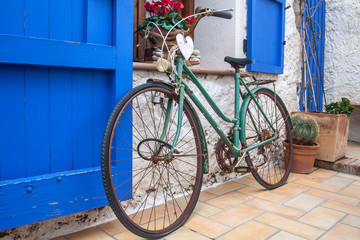 Fototapeta na wymiar Vintage old bicycle in front of cute flowered house in Spain