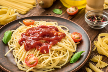 Ready to eat spaghetti with ketchup, tomatoes and basil