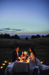 a young couple on a romantic picnic in the evening
