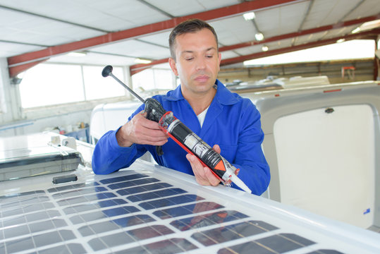 Man applying sealant around solar panel