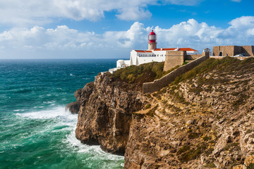 Fototapeta na wymiar Lighthouse and cliffs at Cape Saint Vicent in Algarve region on a windy day. Portugal.