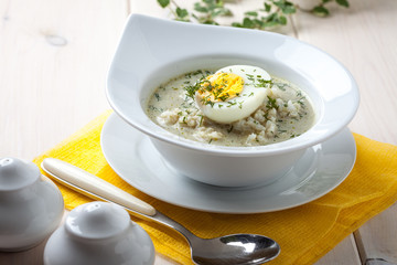 Sorrel soup with egg in white bowl.