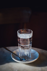 Wasserglas auf Cafétisch
