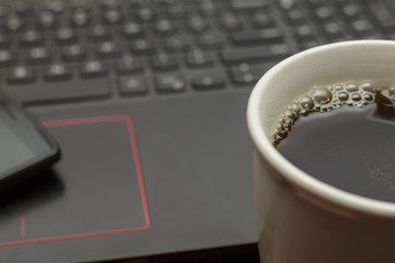 hot cup of coffee with laptop computer