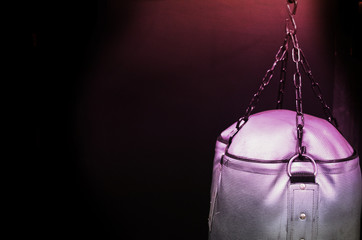 Dark background for boxers.  Punching bag for workout.