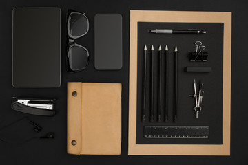 Naklejka premium Office desktop with various black objects on background