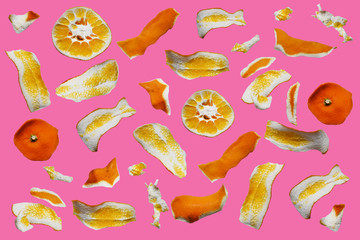 Abstract composition of orange peel pieces, isolated on pink background with clipping path.