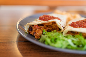 Burrito with Mexican rice served on a plate.